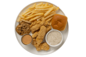 A satisfying chicken strip dinner featuring crispy chicken strips, crinkle-cut fries, a soft roll, country gravy, and dipping sauce.