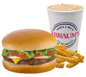 Classic cheeseburger with lettuce, tomato, fries, and a drink.